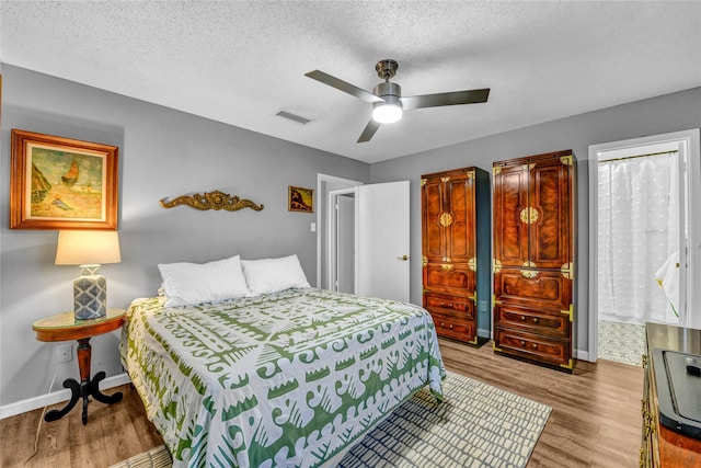 bedroom featuring ceiling fan, a textured ceiling, and light hardwood / wood-style flooring