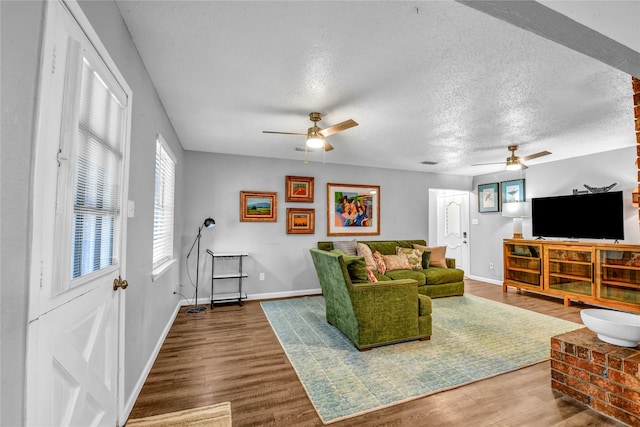 living room with ceiling fan, hardwood / wood-style floors, and a textured ceiling