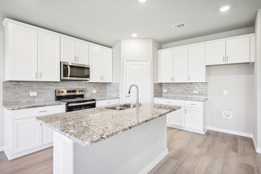 kitchen with sink, white cabinets, and stainless steel appliances