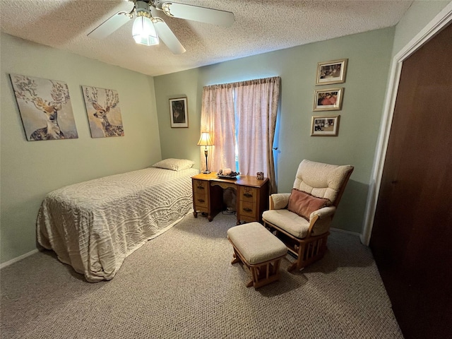 carpeted bedroom featuring ceiling fan and a textured ceiling