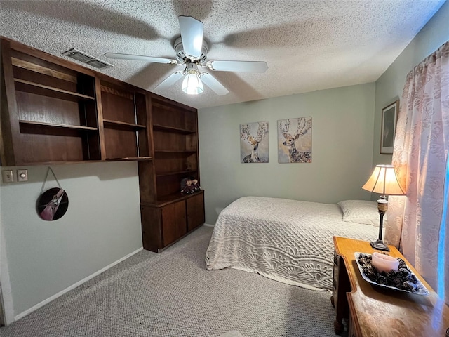 bedroom with ceiling fan, light colored carpet, and a textured ceiling