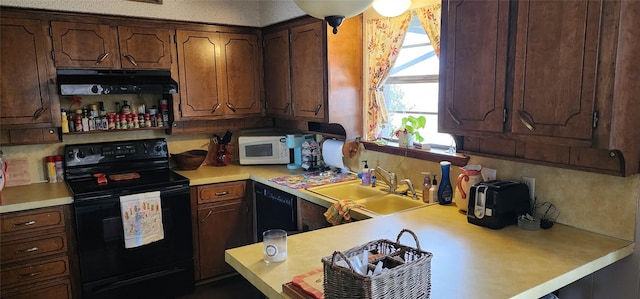 kitchen featuring black appliances, exhaust hood, and sink