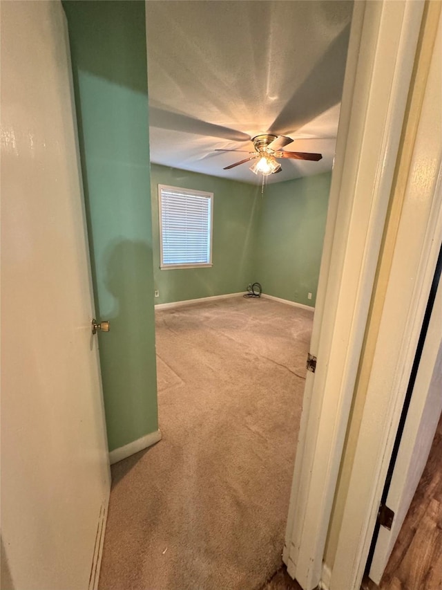 carpeted empty room featuring ceiling fan