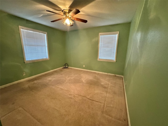 carpeted spare room featuring ceiling fan