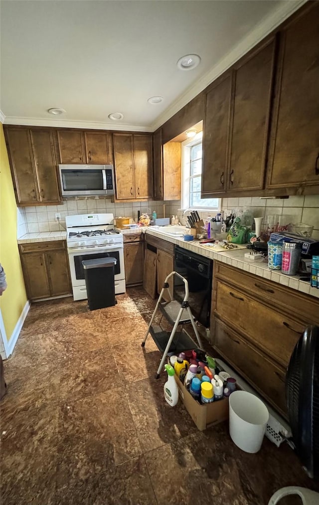 kitchen featuring sink, tile countertops, white gas range, black dishwasher, and backsplash