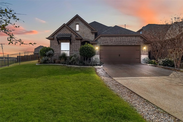 french provincial home with a lawn and a garage