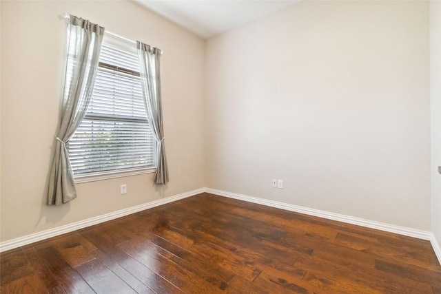 empty room featuring plenty of natural light and dark wood-type flooring