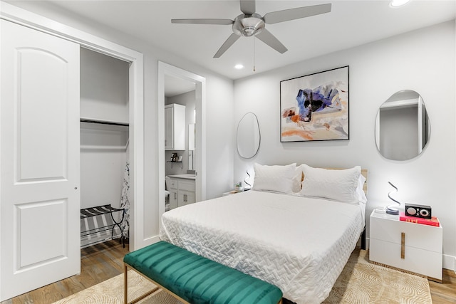 bedroom featuring hardwood / wood-style floors, connected bathroom, a closet, and ceiling fan