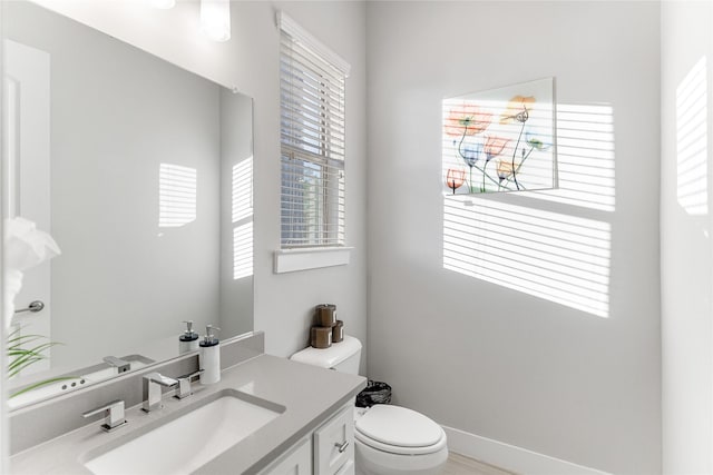 bathroom featuring vanity, toilet, and a healthy amount of sunlight