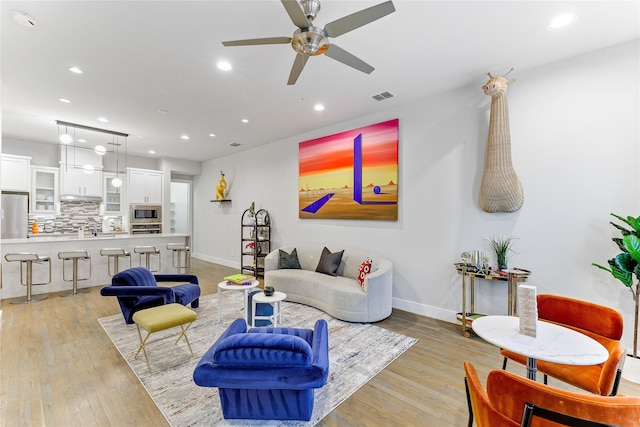 living room featuring ceiling fan and light hardwood / wood-style floors