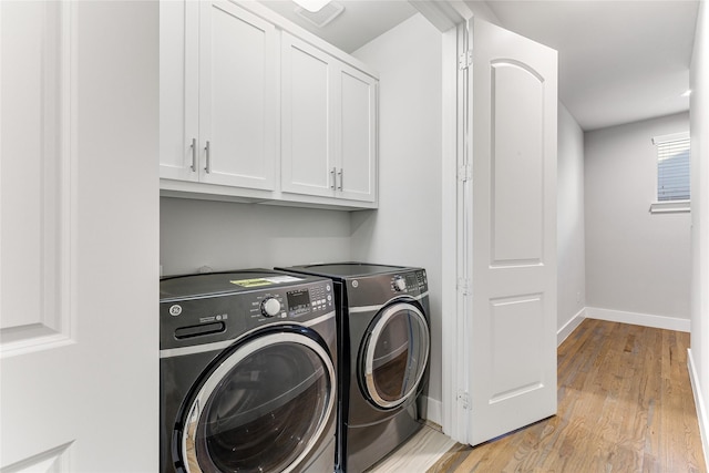 washroom featuring cabinets, independent washer and dryer, and light wood-type flooring