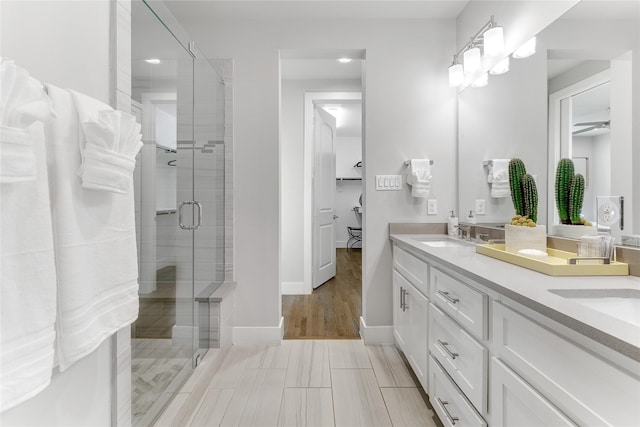 bathroom featuring ceiling fan, vanity, and an enclosed shower