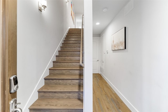 staircase with hardwood / wood-style floors