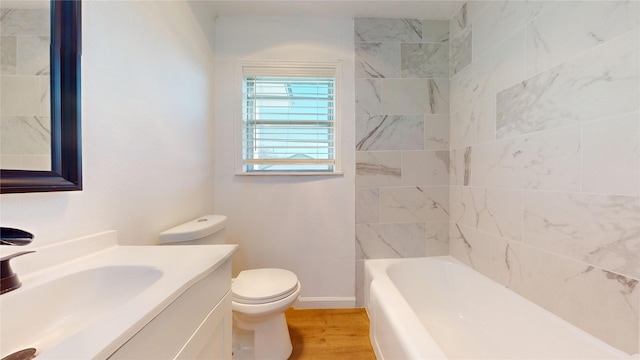 full bathroom featuring vanity, hardwood / wood-style flooring, tiled shower / bath combo, and toilet