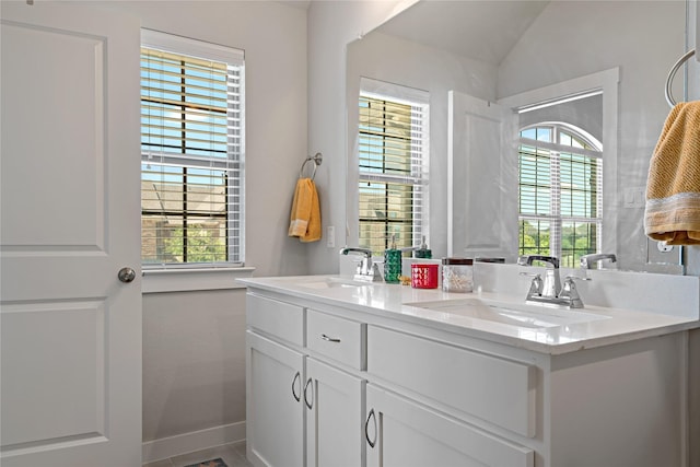 bathroom featuring vanity, vaulted ceiling, and a wealth of natural light