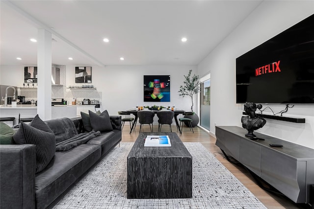 living room with hardwood / wood-style floors and sink