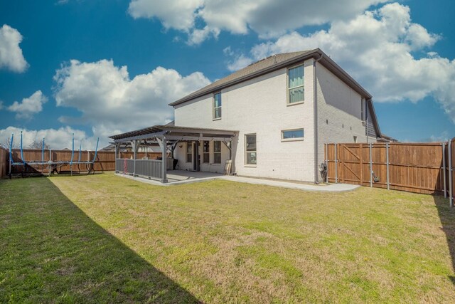 back of property with a lawn, a patio area, and a pergola