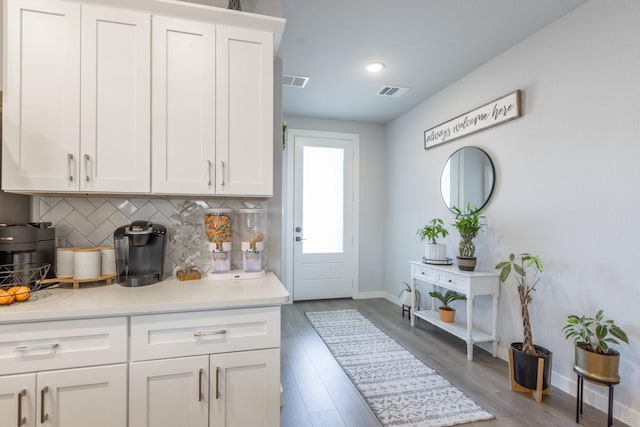 kitchen featuring decorative backsplash, white cabinetry, and light wood-type flooring