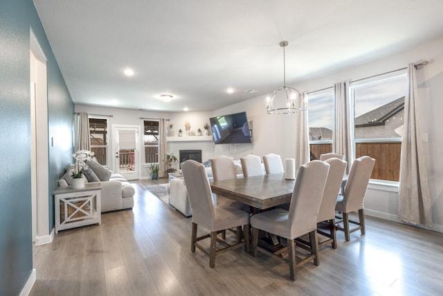 dining room featuring a chandelier, plenty of natural light, and wood-type flooring