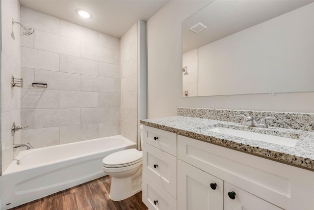 full bathroom with vanity, wood-type flooring, tiled shower / bath combo, and toilet