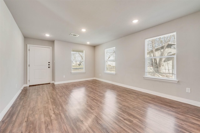 unfurnished room featuring plenty of natural light and hardwood / wood-style flooring