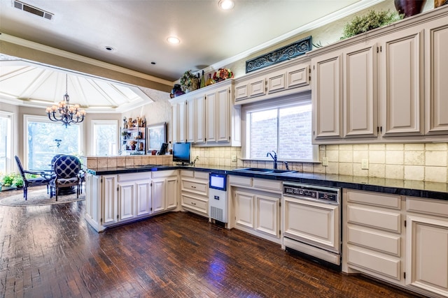 kitchen with kitchen peninsula, ornamental molding, sink, decorative light fixtures, and an inviting chandelier