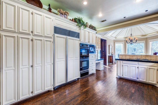 kitchen featuring hanging light fixtures, an inviting chandelier, dark hardwood / wood-style floors, crown molding, and black appliances