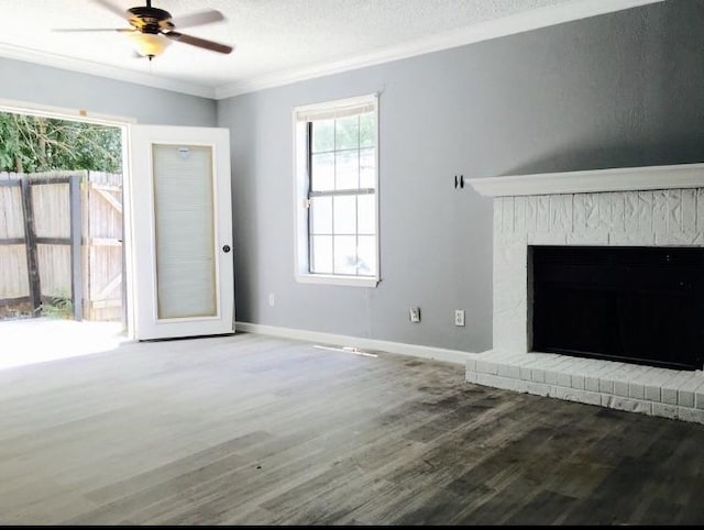 unfurnished living room with hardwood / wood-style flooring, a brick fireplace, ceiling fan, and ornamental molding