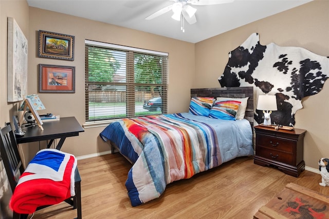 bedroom with multiple windows, ceiling fan, and light hardwood / wood-style floors