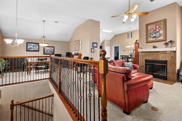 carpeted living room featuring a fireplace, ceiling fan with notable chandelier, and vaulted ceiling