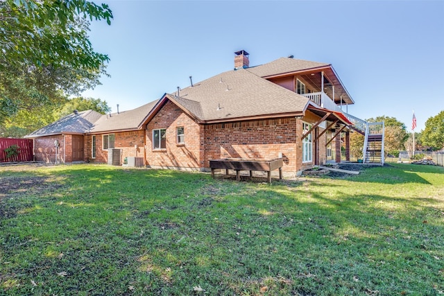 back of property featuring a yard, central AC, and a balcony