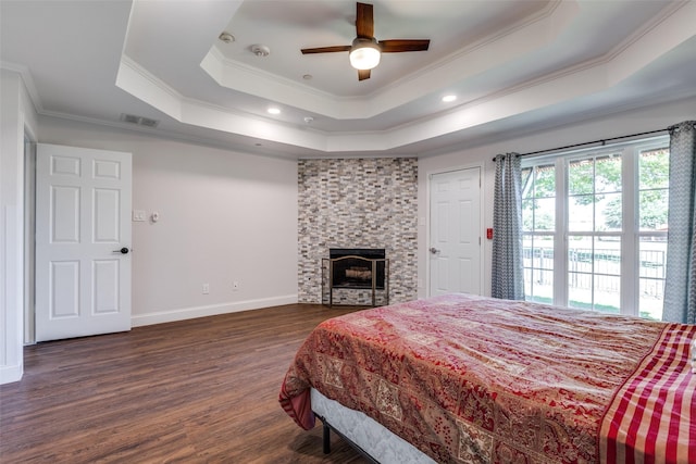 bedroom with a tray ceiling, ceiling fan, crown molding, and dark hardwood / wood-style floors