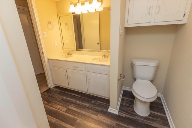 bathroom with hardwood / wood-style flooring, vanity, and toilet