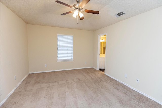 carpeted empty room featuring ceiling fan and a textured ceiling