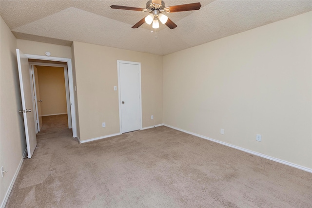 unfurnished bedroom with light carpet, a textured ceiling, lofted ceiling, and ceiling fan