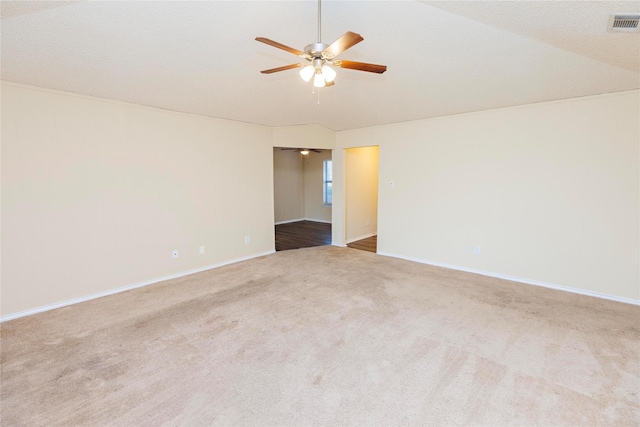 carpeted spare room with vaulted ceiling and ceiling fan