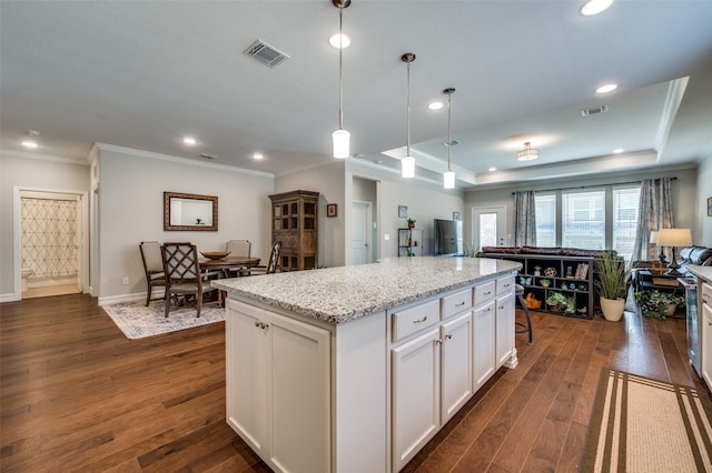 kitchen with white cabinetry, hanging light fixtures, dark hardwood / wood-style flooring, and a center island