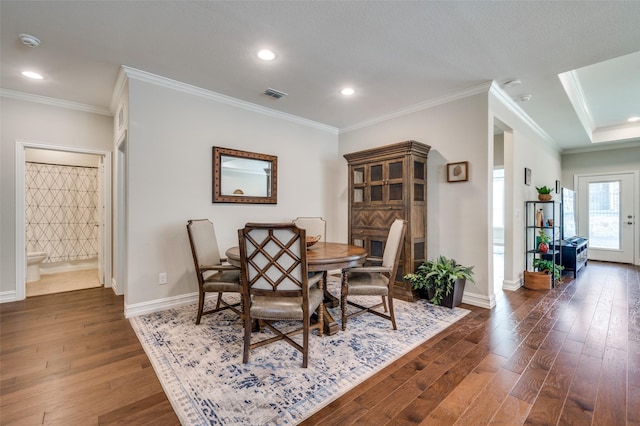 dining area with dark hardwood / wood-style flooring and crown molding