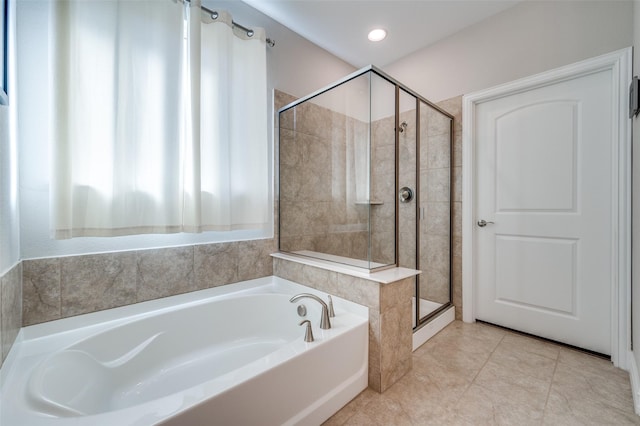 bathroom with tile patterned flooring and separate shower and tub