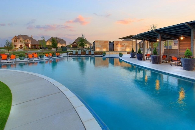 pool at dusk featuring a patio area