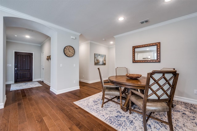 dining room featuring dark hardwood / wood-style flooring and crown molding