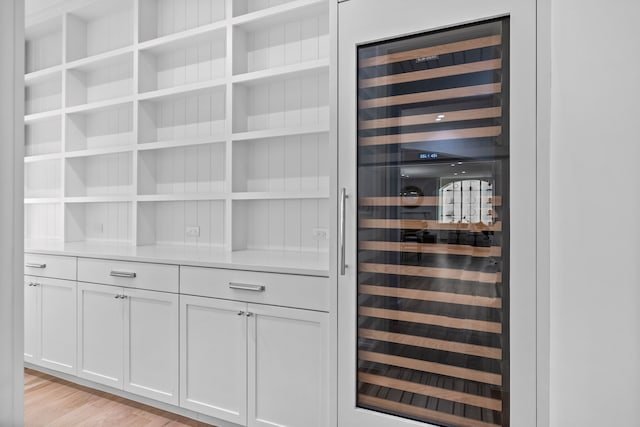 details featuring hardwood / wood-style flooring and wine cooler