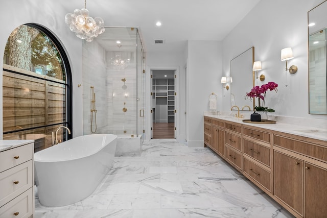 bathroom with vanity, a notable chandelier, and shower with separate bathtub