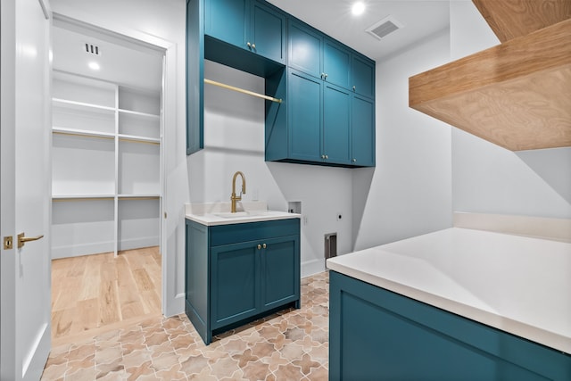 laundry area with hookup for an electric dryer, hookup for a washing machine, cabinets, and sink