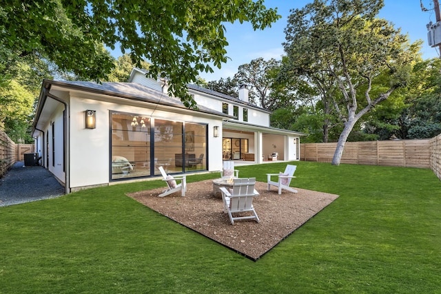 back of house featuring a yard, central AC, and an outdoor fire pit