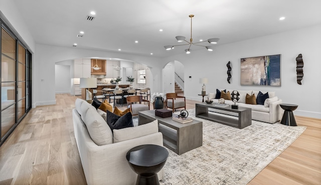 living room featuring an inviting chandelier and light hardwood / wood-style floors