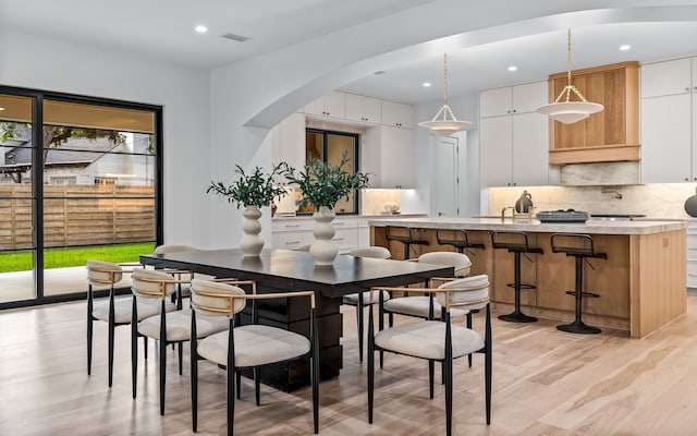 dining space featuring sink and light wood-type flooring