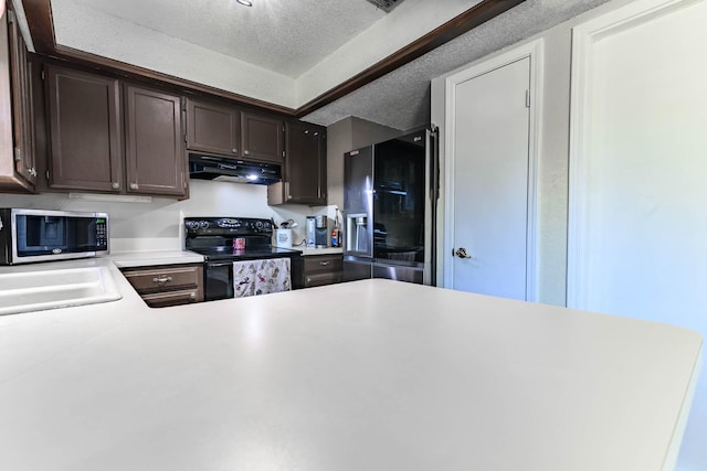 kitchen featuring sink, dark brown cabinets, a textured ceiling, and appliances with stainless steel finishes