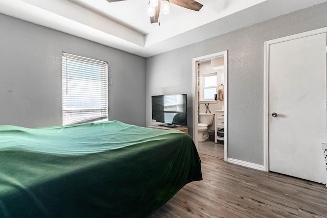 bedroom featuring hardwood / wood-style flooring, ceiling fan, and connected bathroom