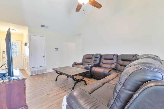 living room with ceiling fan, high vaulted ceiling, and light wood-type flooring